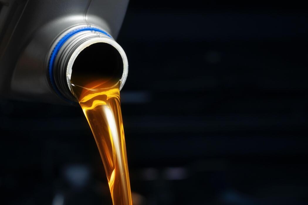 Fresh engine oil being poured during a car service